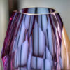 top detail of pink and purple hue crystal faceted vase hand-cut entirely by glass artisan place on top of table centrepiece