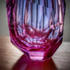 bottom detail of pink and purple hue crystal faceted vase hand-cut entirely by glass artisan place on top of table centrepiece